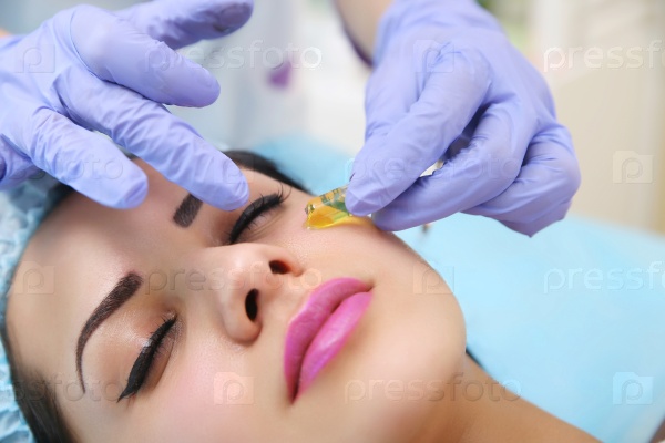 Vitamin in cosmetic ampoule. Doctor gets his hands beautician vitamin serum to the face of a beautiful woman, stock photo
