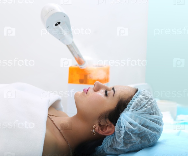 Woman getting steam on her face in spa.