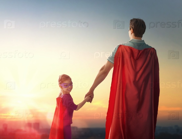 Happy loving family. Father and his daughter child girl playing outdoors. Daddy and his child girl in an Superhero\'s costumes. Concept of Father\'s day.