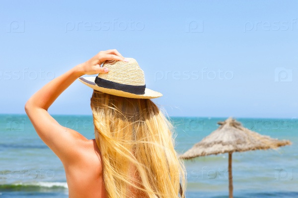 Sexy young blond fashionable woman posing in a golden bikini