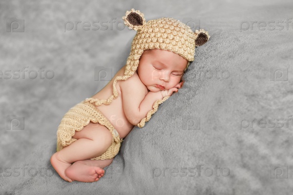 Little newborn baby boy 7 days, sleeps. newborn baby curled up sleeping on a blanket. Eight day old smiling newborn baby boy.