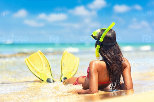 Beach vacation snorkel girl snorkeling with mask and fins. Bikini woman relaxing on summer holidays lying down in water after snorkelling with snorkel tuba and flippers sun tanning.