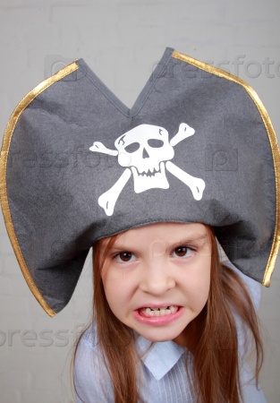 Image of a beautiful young girl in the role of an evil pirate terrible on gray background on Holiday