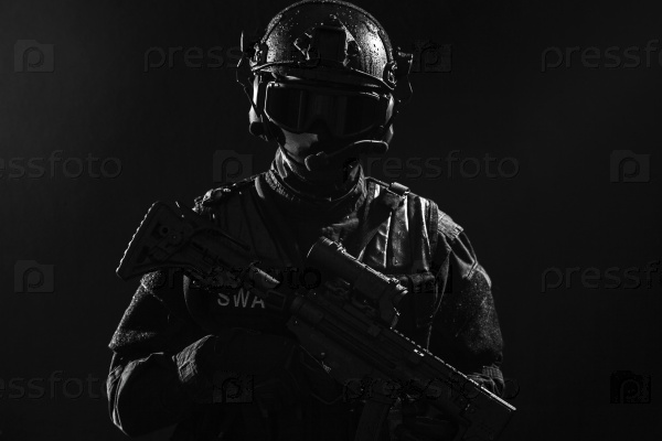 Spec ops police officer SWAT in black uniform and face mask studio shot, stock photo