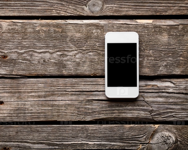White smart phone with isolated screen on old wooden desk.
