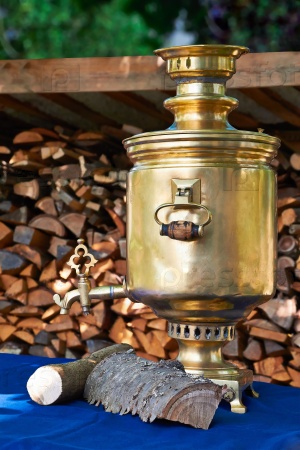 The retro russian  samovar with woods on a summer day