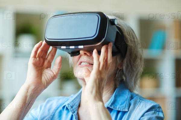 Пожилая женщина в очках виртуальной реальности