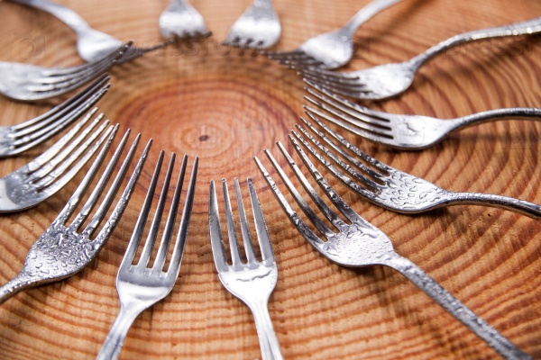 Series of different forks in a circle of pine board