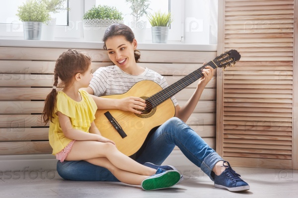 Мать и дочь играют на гитаре