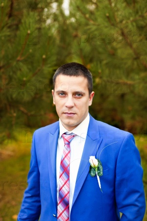 Portrait of the groom in the park on their wedding day