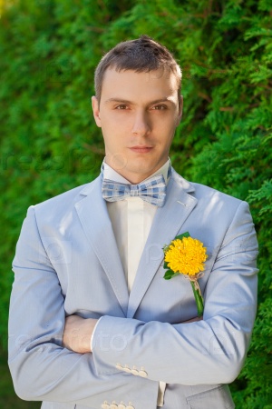 Stylish groom.Portrait of the groom in the park on their wedding day.Portrait of a handsome groom in a blue suit and white shirt