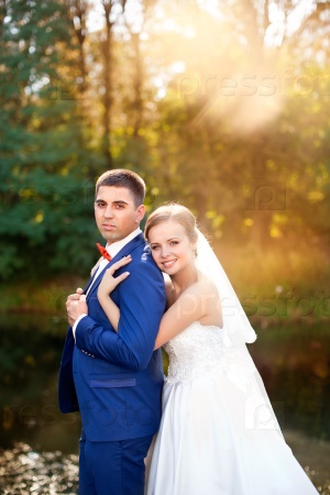 Groom gently hugged the bride.Bride and groom enjoy moments of happiness in wedding summer day.The couple posing in their wedding day outdoors