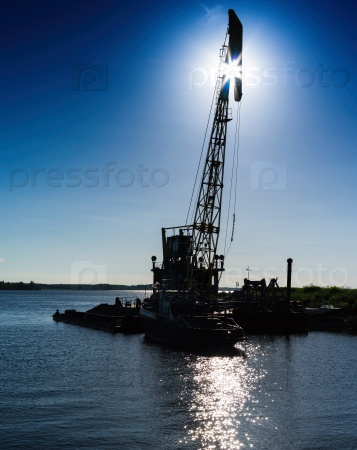 Vertical vivid lifting hoisting crane ship silhouette back light horizon background backdrop