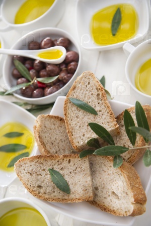 Presentation of wholemeal bread and olives with olive oil