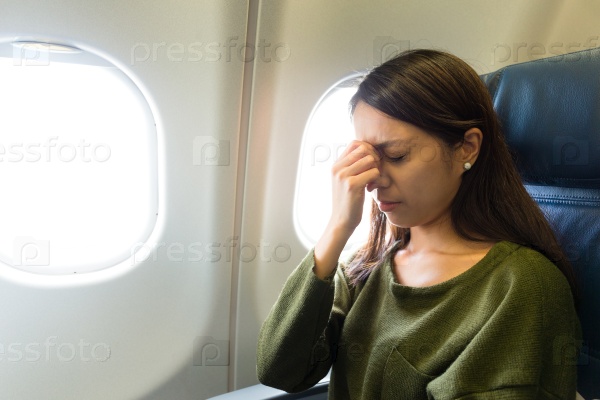 Fear of flying woman in plane airsick with stress headache