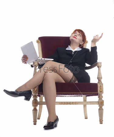 Девушка сидит на стуле в клетчатой мини-юбке с подтяжками