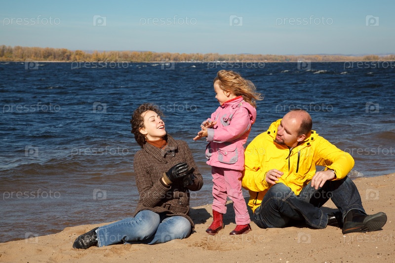 на пляже девочка Фотография на тему Девочка вместе с родителями на пляже в солнечный осенний  день | PressFoto