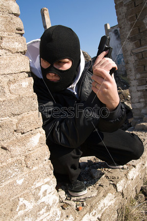 Бандит в маске с пистолетом ожидании жертвы