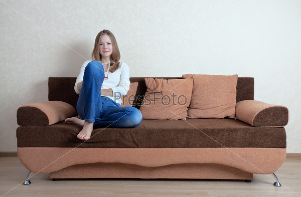 Девушка сидит на леопардовом диване.