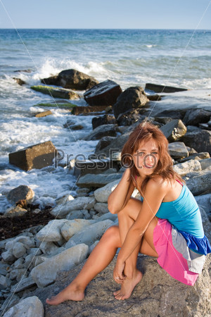 Симпатичная девушка позирует на берегу моря
