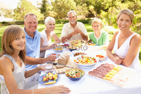 Фотография на тему Большая семья обедает в саду | PressFoto