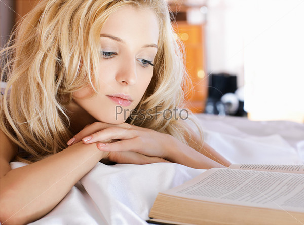 Кудрявая блондинка в розовом белье на кровати