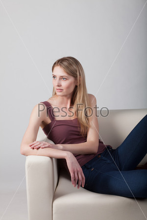 Голая девушка сидит на диване - фото