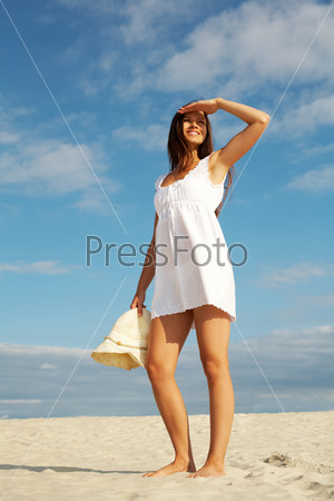 Красивая молодая сексуальная женщина в белом платье на море