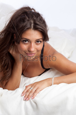 Красивая женщина лежит на кровати модное фото сексуальной дамы