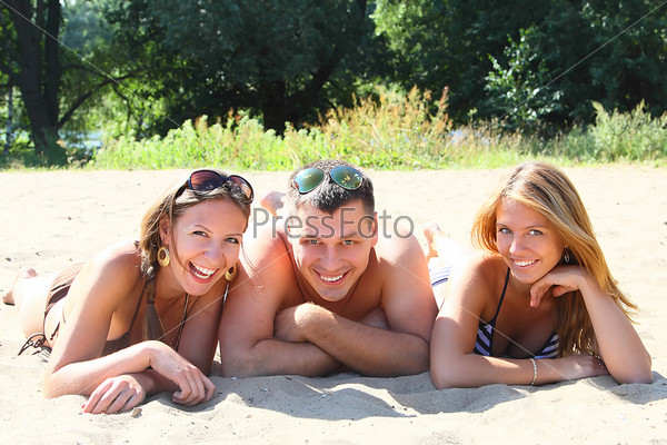 Три мужика развлекаются на берегу с грудастой подружкой