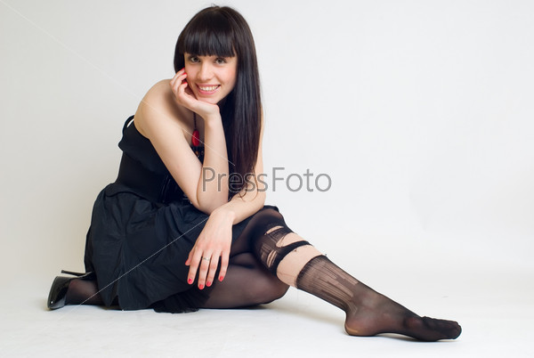 Фотография на тему Молодая сексуальная брюнетка в рваных чулках на светлом фоне | PressFoto