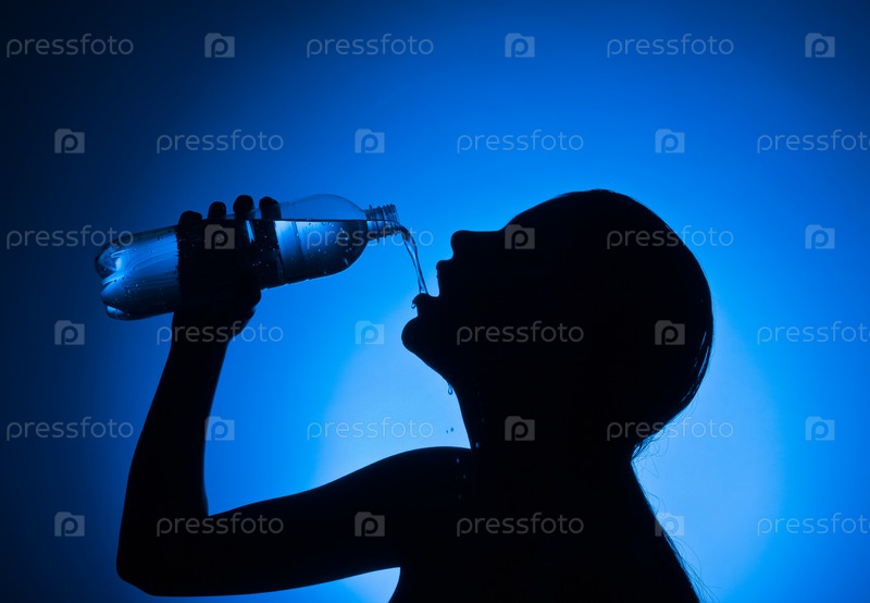 Фотография на тему Женщина пьет воду из бутылки, на синем фоне | PressFoto