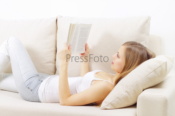Молодая блондинка лежит на диване и смотрит в камеру | Премиум Фото