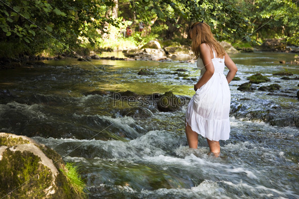 Красивая девушка в мокром полупрозрачном белом платье в воде. Человек и природа.