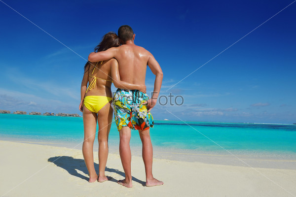 Фотография на тему Счастливая молодая пара наслаждается летом на пляже | PressFoto