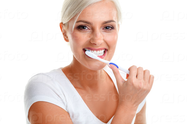 Девушка чистит зубы на синем фоне студии. | Премиум Фото