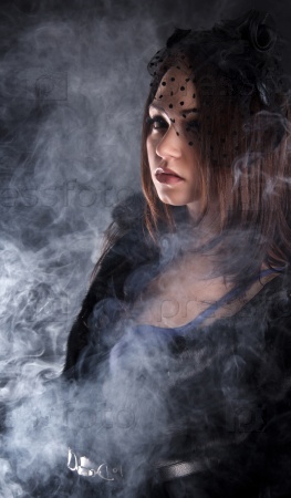 Женщина стоит, пуская дым