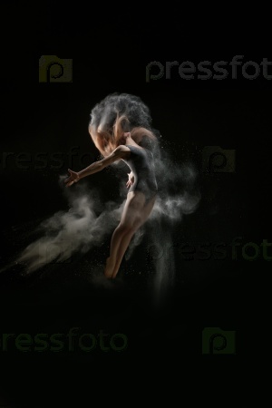 Красивая девушка-зайчик, идущая вдаль перед объемным светом на черном фоне с частицами пыли