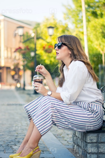 девушка в стиле оверсайз с кофе в руке на улице города
