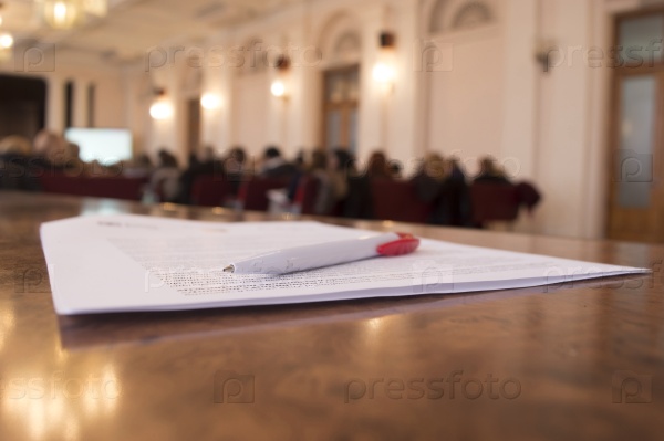 Ручка на бумаге на фоне пресс-конференции
