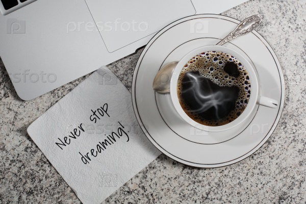 Чашка кофе, блокнот и салфетка с мотивацией