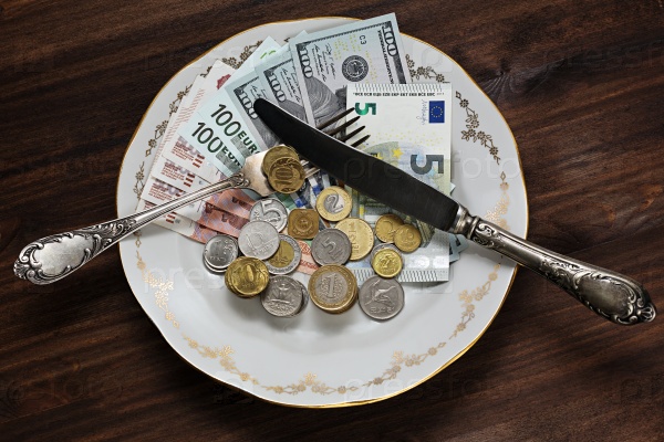 Деньги разных стран на тарелке