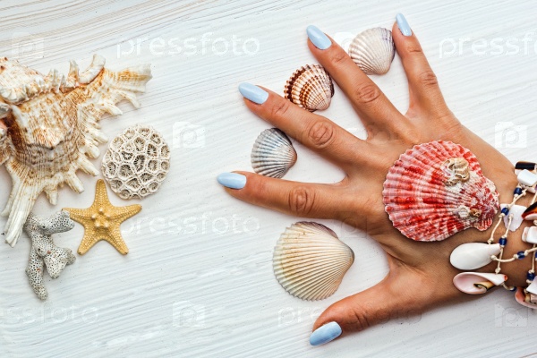 Женские руки с маникюром и морскими раковинами