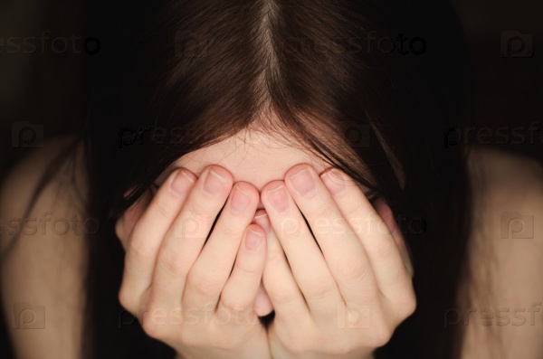 Женщина закрывает лицо руками