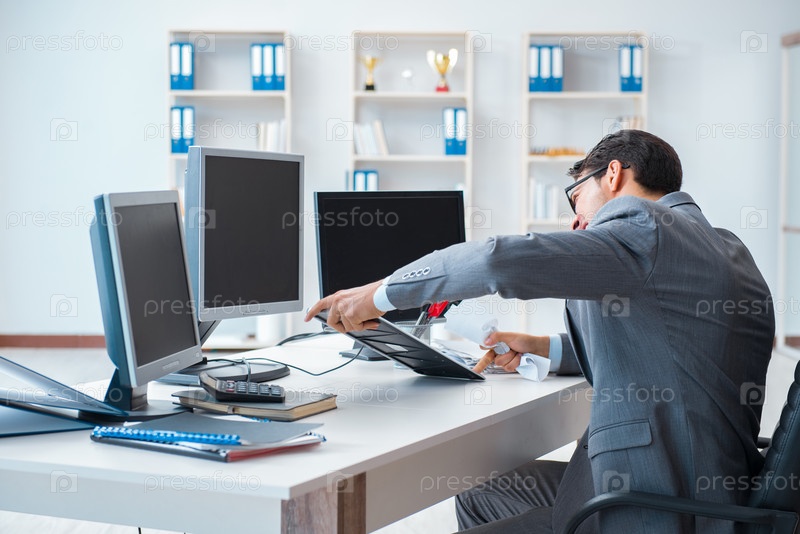Businessman sitting in front of many screens
