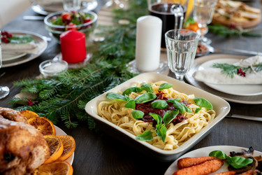 Праздничный стол подается с макаронами, жареной индейкой, тарелками, свечами и другими - Pressmaster