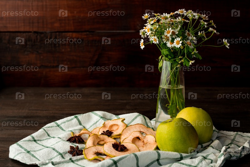 Fresh granny smith apples, vase with garden flowers, dry fruit and star anise