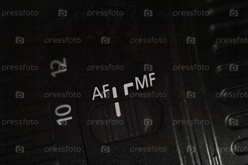 Крупный план переключателя AF MF на объективе камеры. Ползунок для изменения режима автофокуса. Темный фон