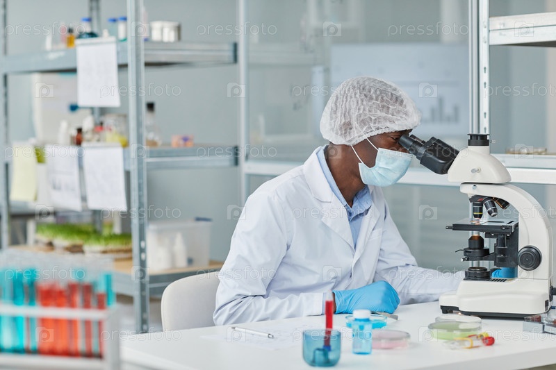 Scientist examining virus with microscope