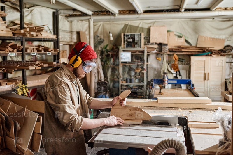 Man Cutting Wooden Detail In Workshop